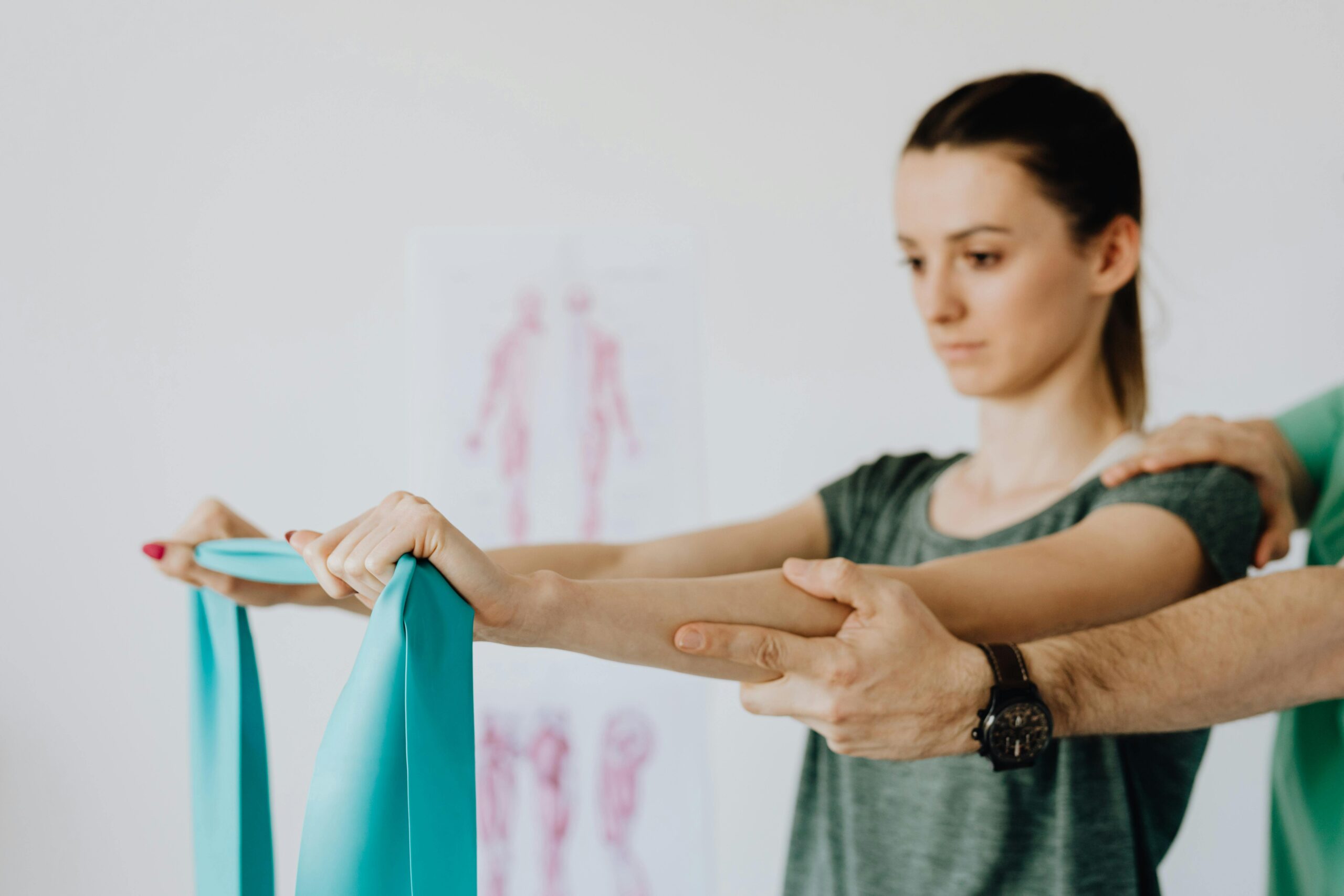 Physiotherapist correcting a patient’s posture during a resistance band exercise